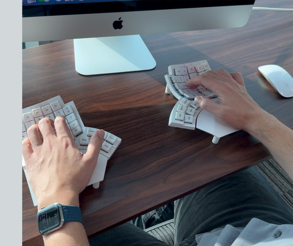 Top-down view of Glove80 ergonomic keyboard in use for coding