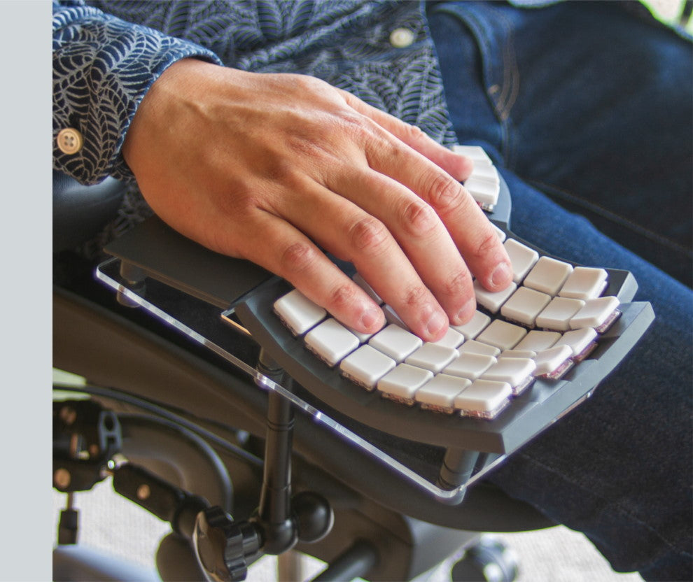 Close-up of chair mounted Glove80 ergonomic keyboard in use